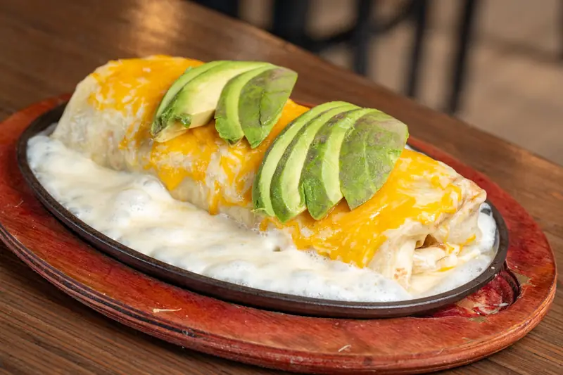 Burrito California smothered in cheese on a skillet