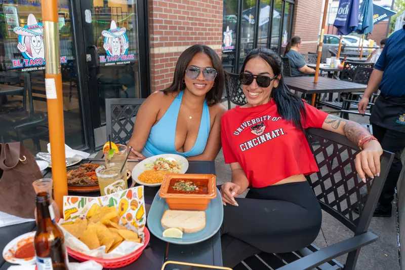 Two friends on the patio, one in a University of Cincinnati shirt